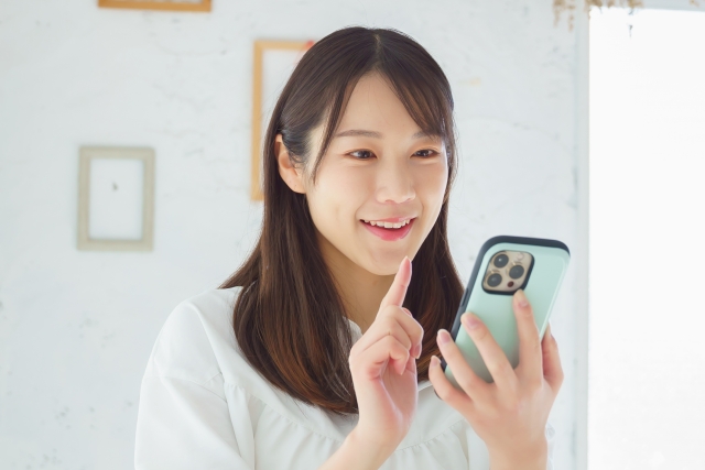 （写真）スマホを操作する女性