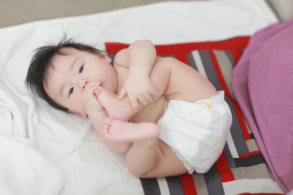 （写真）風呂敷の上に寝転ぶ赤ちゃん